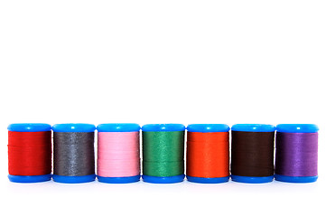 Image showing Row of colorful thread spools