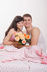 Image showing Happy young beautiful couple sitting in bed