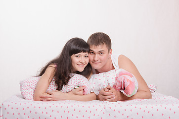 Image showing Girl and guy lie embracing in bed