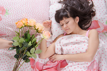 Image showing Sleeping beautiful girl presented with a bouquet of flowers