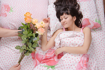 Image showing Sleeping girl presented with a bouquet of roses