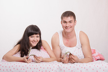 Image showing girl and guy with a wad of money in bed