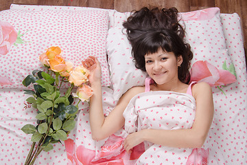 Image showing Young happy girl on the bed of flowers