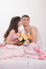 Image showing Grateful for the donated flowers girl kissing guy