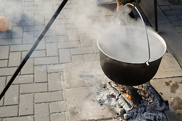 Image showing pot with food on metal rods vaporize on fire 