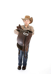 Image showing Boy carrying a saddle