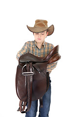 Image showing Rural boy holding a saddle