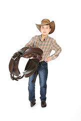 Image showing Young rider holding a saddle