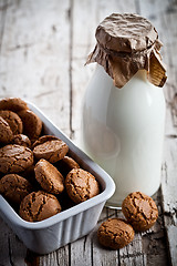 Image showing meringue almond cookies in a bowl and bottle of milk 