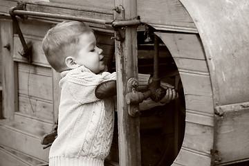 Image showing 2 years old curious Baby boy managing with old agricultural Mach