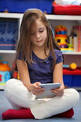 Image showing Happy pre-teen girl using a digital tablet computer