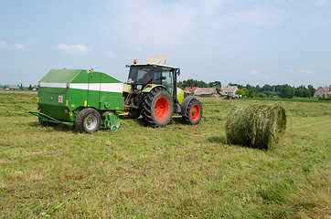 Image showing tractor bailer collect hay in agriculture field 