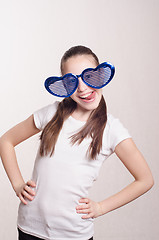 Image showing Funny little girl in big glasses showing tongue