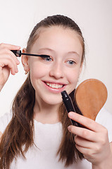 Image showing Teenager paints eyelashes mascara