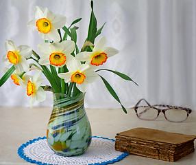 Image showing Blossoming narcissuses in a vase on a table.