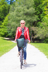 Image showing Young woman riding a bicycle.