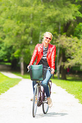 Image showing Young woman riding a bicycle.