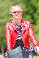 Image showing Young woman riding a bicycle.