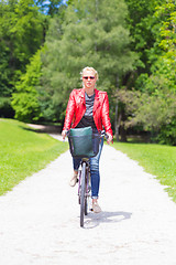 Image showing Young woman riding a bicycle.