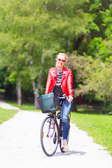 Image showing Young woman riding a bicycle.