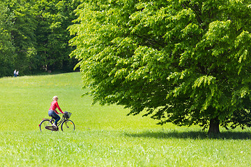 Image showing Young woman riding a bicycle.