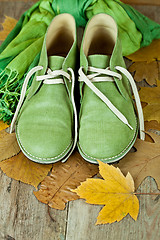 Image showing pair of green leather boots, scarf and yellow leaves