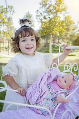 Image showing Adorable Young Baby Girl Playing with Baby Doll and Carriage
