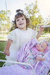 Image showing Adorable Young Baby Girl Playing with Baby Doll and Carriage