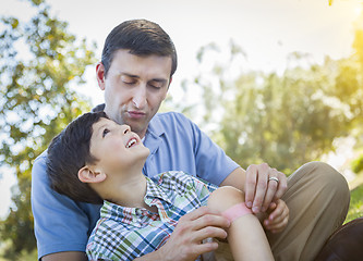 Image showing Loving Father Puts Bandage on Knee of Young Son