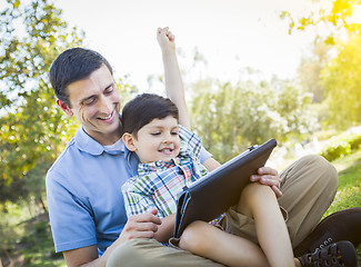 Image showing Handsome Mixed Race Father and Son Playing on Computer Tablet