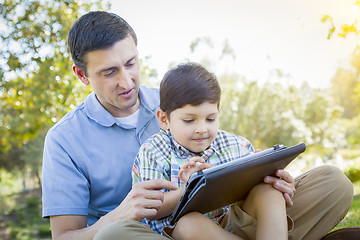 Image showing Handsome Mixed Race Father and Son Playing on Computer Tablet