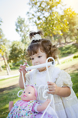 Image showing Adorable Young Baby Girl Playing with Baby Doll and Carriage