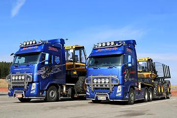 Image showing Two Volvo FH13 Trucks Hauling Ponsse Forestry Machinery