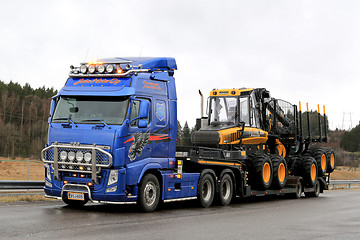 Image showing Blue Volvo FH13 Truck Hauls Ponsse Forwarder