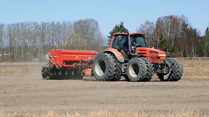 Image showing Same Agricultural Tractor and Seeder on Field at Spring