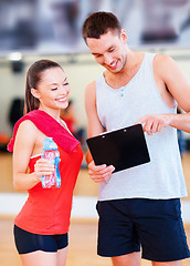 Image showing smiling male trainer with woman in the gym