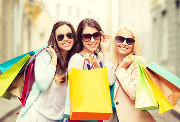 Image showing three smiling girls with shopping bags in ctiy