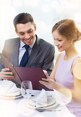 Image showing smiling couple with menu at restaurant