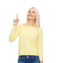 Image showing smiling woman pointing her finger up