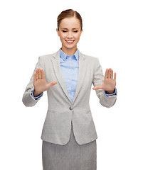 Image showing smiling businesswoman pointing to something