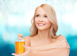 Image showing happy woman with oil bottle