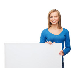 Image showing smiling woman in sweater with blank white board