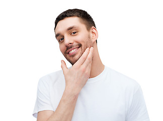 Image showing beautiful smiling man touching his face