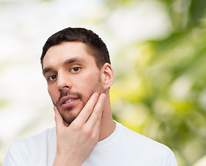 Image showing beautiful calm man touching his face