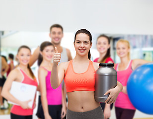 Image showing teenage girl with jar of protein showing thumbs up