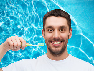 Image showing smiling young man with toothbrush