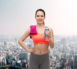 Image showing sporty woman with towel and water bottle