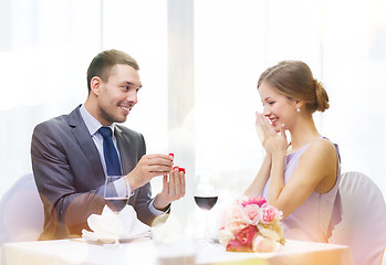 Image showing man proposing to his girlfriend at restaurant