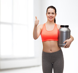 Image showing teenage girl with jar of protein showing thumbs up