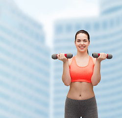 Image showing young sporty woman with light dumbbells